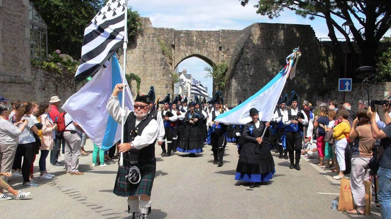 défilé en costumes bretons et drapeau Gwenn ha du devant les remparts de Guérande