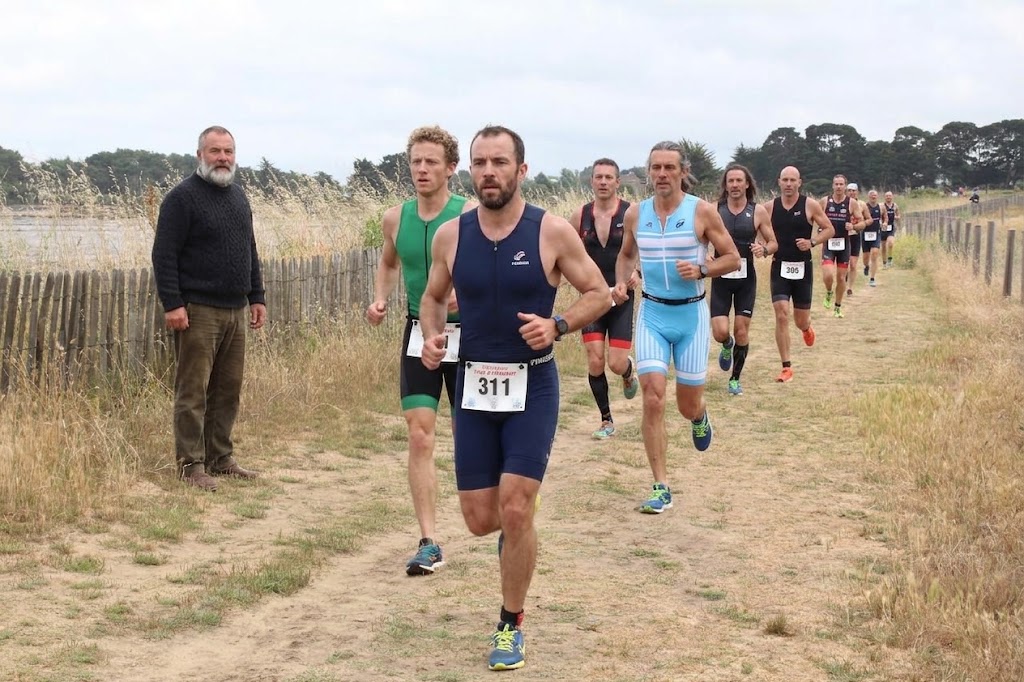 coureurs de triathlon sur un sentier côtier bordé de marais